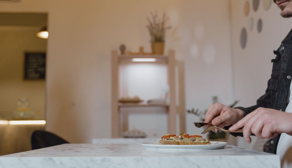 A man enjoying a healthy vegan meal in a cozy indoor cafe setting.