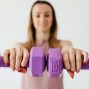 Defocused content young female doing bicep exercise with dumbbells during functional training in light studio